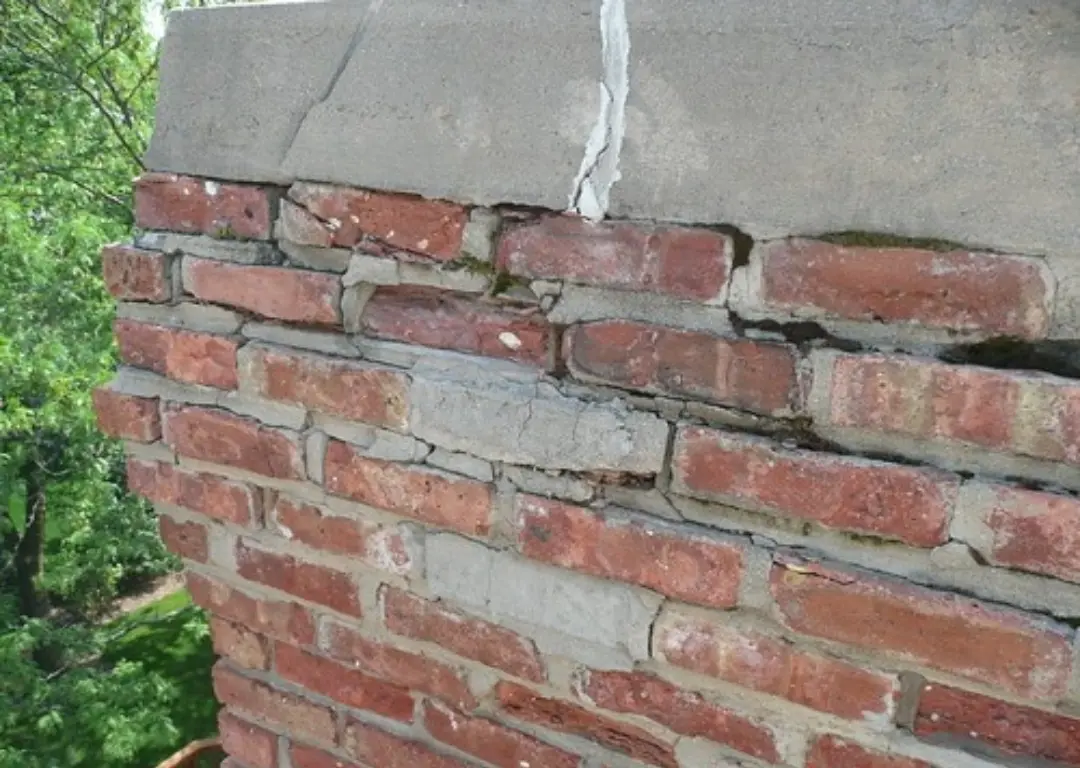 Show a skilled mason delicately removing deteriorated mortar joints from a chimney, followed by precisely applying fresh mortar in a contrasting color.